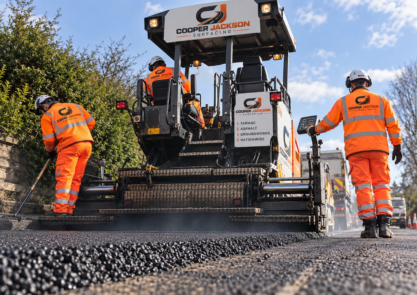 Cooper Jackson Surfacing crew laying asphalt surface course with a paver on a road resurfacing job